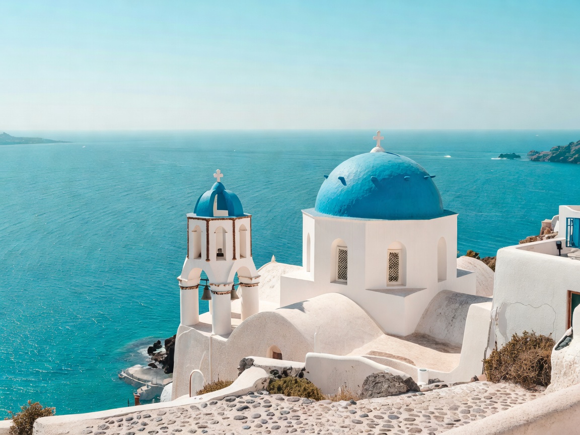 Santorini blue domed church against turquoise sea